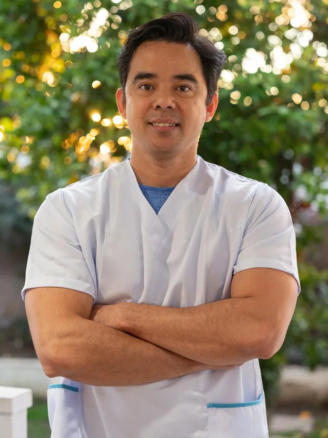 Professional caregiver in medical scrubs smiling confidently in outdoor setting