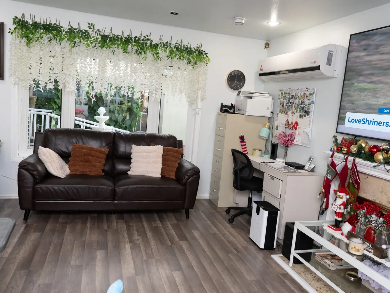 Comfortable common area with leather sofa and workspace decorated with white hanging florals and seasonal decorations